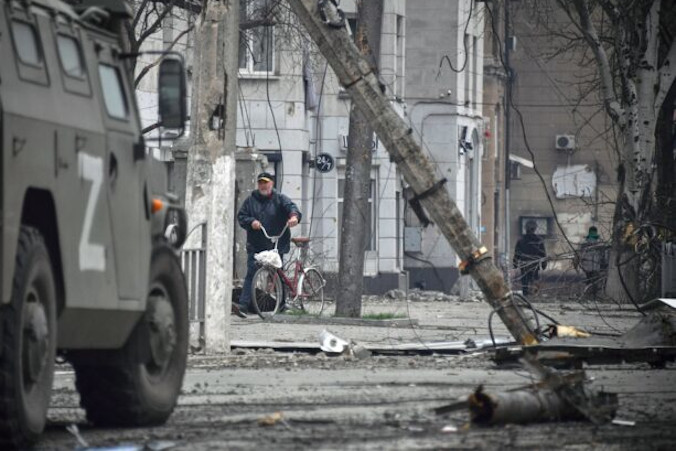 Mężczyzna idzie z rowerem w centrum Mariupola, 12.04.2022 r. (Alexander Nemenov/AFP via Getty Images)