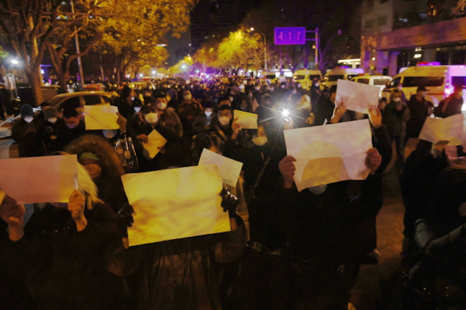  Protestujący trzymają puste białe kartki papieru podczas protestu, którego bezpośrednią przyczyną był pożar w Urumqi, zginęło w nim co najmniej 10 osób, Pekin, Chiny, 27.11.2022 r. Protesty przeciwko nieludzkim restrykcjom antycovidowym w Chinach wybuchły w różnych miastach, w tym w Pekinie i Szanghaju. Puste kartki są symbolem protestu przeciwko cenzurze (MARK R. CRISTINO/PAP/EPA)