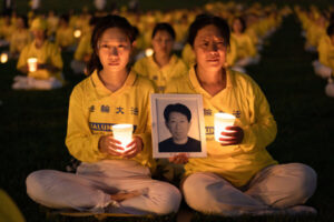 Li Xiaohua i jej matka Ju Reihjong uczestniczą w czuwaniu przy świecach, aby upamiętnić ofiary trwających od 23 lat prześladowań Falun Gong w Chinach, czuwanie miało miejsce pod pomnikiem w Waszyngtonie, 21.07.2022 r. Ju trzyma zdjęcie Li Delonga, swojego męża i ojca Li Xiaohua, który zmarł na skutek prześladowań (Samira Bouaou / The Epoch Times)