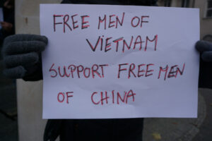  Uczestnik protestu przed Biurem Parlamentu Europejskiego w Polsce trzyma kartkę z napisem „Wolni ludzie z Wietnamu wspierają wolnych ludzi z Chin”, Warszawa, 3.12.2022 r. (The Epoch Times)