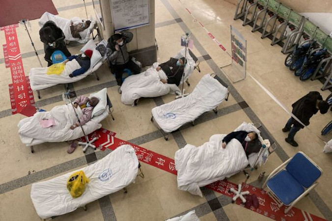 Pacjenci zarażeni koronawirusem COVID-19 leżą na szpitalnych łóżkach w holu Szpitala Ludowego nr 5 w mieście Chongqing na południowym zachodzie Chin, 23.12.2022 r. (Noel Celis/AFP via Getty Images)
