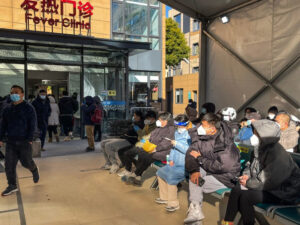 Ludzie czekają na pomoc medyczną na terenie kliniki leczenia gorączki szpitala Tongren w dzielnicy Changning w Szanghaju, 23.12.2022 r. (Hector Retamal/AFP via Getty Images)