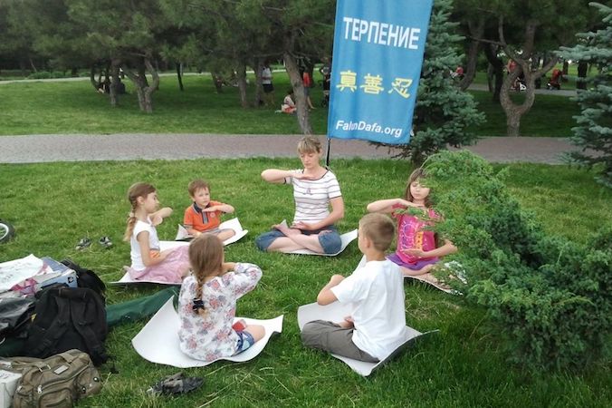 Ludmyła Oreł wykonuje piąte ćwiczenie Falun Gong z dziećmi w parku (fot. dzięki uprzejmości Denysa Nahorniuka, za pośrednictwem Arminy Nimenko)
