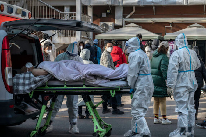 Pracownicy służby zdrowia przywożą pacjenta na noszach do kliniki leczenia gorączki w Pekinie, 9.12.2022 r. (Kevin Frayer / Getty Images)