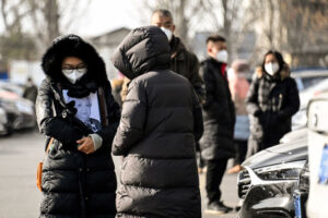 Kobieta trzyma oprawione zdjęcie bliskiej osoby na terenie krematorium w Pekinie, 20.12.2022 r. Pracownicy krematoriów w Pekinie powiedzieli 16 grudnia 2022 r., że są przytłoczeni gwałtownym wzrostem liczby przypadków COVID-19 w Chinach (Noel Celis/AFP via Getty Images)
