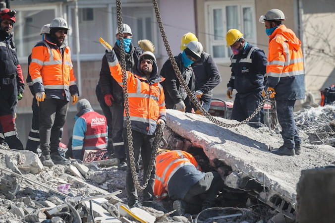 Członkowie grupy poszukiwawczo-ratowniczej pracują wśród gruzów budynku zawalonego w następstwie trzęsienia ziemi, Nurdağı w południowo-wschodniej Turcji, 13.02.2023 r. (JOAO RELVAS/PAP/EPA)