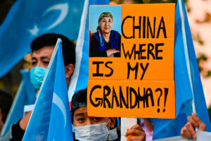Młody aktywista ujgurski trzyma plakat z napisem: „Chiny, gdzie jest moja babcia?!”. podczas demonstracji przed MSZ w Berlinie, gdzie chiński minister spraw zagranicznych miał odbyć rozmowy ze swoim niemieckim odpowiednikiem, 1.09.2020 r. (Tobias Schwarz/AFP via Getty Images)