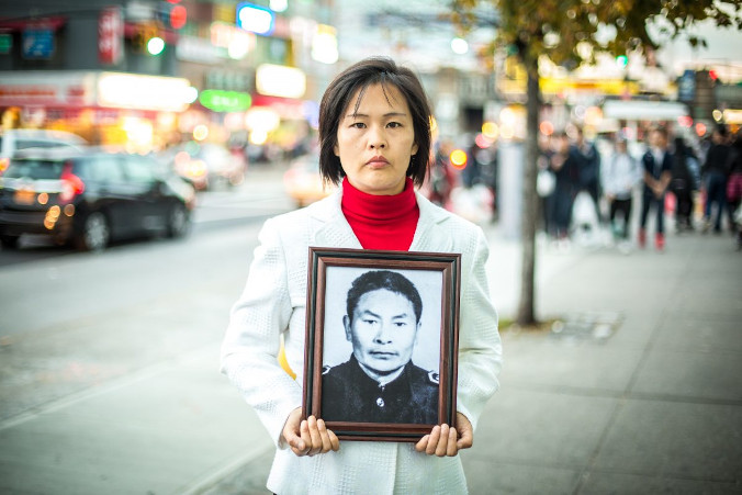 Jiang Li trzyma zdjęcie ojca, który został zabity przez Komunistyczną Partię Chin w Chinach za praktykowanie Falun Gong, Flushing w dzielnicy Queens, Nowy Jork, 1.11.2015 r. (Benjamin Chasteen / The Epoch Times)