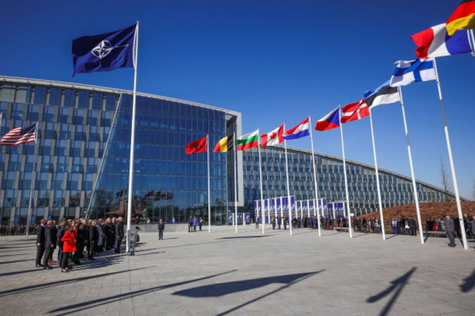 Urzędnicy uczestniczą w ceremonii podniesienia flagi z okazji przystąpienia Finlandii do NATO podczas spotkania ministrów spraw zagranicznych NATO w siedzibie Sojuszu w Brukseli, Belgia, 4.04.2023 r. (OLIVIER MATTHYS/POOL/PAP/EPA)