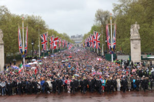 Tłumy ludzi czekają, by przejść w stronę Pałacu Buckingham po powrocie brytyjskiego króla Karola III i królowej Camilli z ceremonii koronacyjnej, Londyn, Wielka Brytania, 6.05.2023 r. (PAP/EPA/STR)