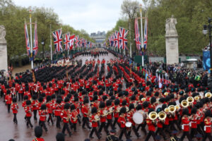 Orkiestra Gwardii Królewskiej maszeruje przed królem Wielkiej Brytanii Karolem III i królową Camillą, gdy wracają do Pałacu Buckingham po ceremonii koronacyjnej w Londynie, Wielka Brytania, 6.05.2023 r. (PAP/EPA/STR)