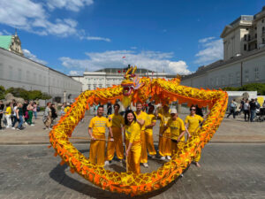 Praktykujący Falun Dafa prezentują taniec Złotego Smoka podczas parady z okazji Światowego Dnia Falun Dafa, Krakowskie Przedmieście przed Pałacem Prezydenckim w Warszawie, 13.05.2023 r. (Marcin Hakemer-Fernandez)