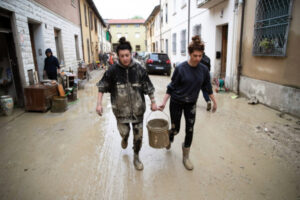 Ludzie sprzątają swoje domy ze zniszczeń po powodzi, która dotknęła Emilię-Romanię, Faenza we Włoszech, 19.05.2023 r. Faenza leży w odległości ok. 15 km w linii prostej od Forli (EMANUELE VALERI/PAP/EPA/EMANUELE VALERI)