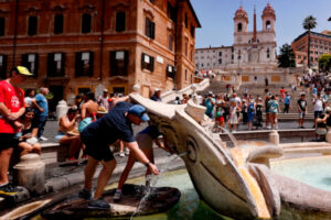 Ludzie chłodzą się w fontannie podczas upalnego letniego dnia na Piazza di Spagna w Rzymie, Włochy, 8.07.2023 r. (FABIO FRUSTACI/PAP/EPA)