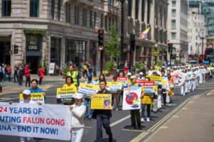 Hu Xuanming (w drugim rzędzie po prawej) podczas marszu upamiętniającego 24. rocznicę rozpoczęcia przez chiński reżim prześladowań wymierzonych w Falun Gong, Londyn, 15.07.2023 r. Matka Hu jest więziona w Chinach (Yanning Qi / The Epoch Times)