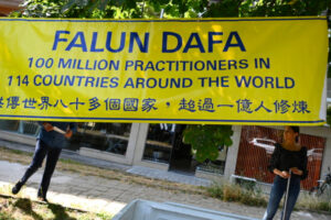 Członkowie bułgarskiego stowarzyszenia Falun Dafa stoją obok transparentu w ramach cichego protestu przed ambasadą Chin w Sofii, Bułgaria, 20.07.2023 r. Protest upamiętnia 24. rocznicę rozpoczęcia masowej kampanii przeciwko Falun Dafa w dniu 20 lipca 1999 r., kiedy to chiński reżim komunistyczny rozpoczął represje i prześladowania Falun Gong i jego zwolenników w Chinach. Brutalne represje, które obejmują również przymusowe pobieranie narządów od żyjących wyznawców duchowej dyscypliny Falun Dafa w Chinach, znanej również jako Falun Gong, trwają od 24 lat (VASSIL DONEV/PAP/EPA)