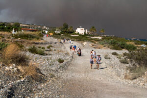 Ludzie ewakuują się z miejscowości Kiotari podczas pożaru na wyspie Rodos, Grecja, 22.07.2023 r. (DAMIANIDIS LEFTERIS/PAP/EPA)