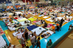 Turyści i mieszkańcy śpią w hali sportowej Venetokleio, która została przekształcona w schronienie po pożarze, wyspa Rodos w Grecji, 23.07.2023 r. (DAMIANIDIS LEFTERIS/PAP/EPA)