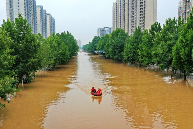 Ratownicy płyną, by ewakuować ludzi poszkodowanych na skutek powodzi, Zhuozhou w prowincji Hebei na północy Chin, 2.08.2023 r., zdjęcie z lotu ptaka (PAP/EPA/XINHUA / Mu Yu)