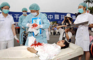 Praktykujący Falun Gong podczas rekonstrukcji procederu Komunistycznej Partii Chin polegającego na grabieży organów od praktykujących Falun Gong, wiec w Tajpej na Tajwanie, 23.04.2006 r. (Patrick Lin/AFP via Getty Images)