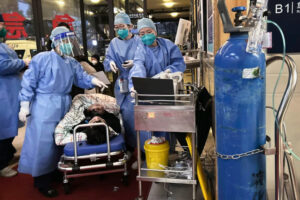 Pracownicy służby zdrowia zajmują się pacjentem z COVID-19 w Szanghaju, 14.01.2023 r. W ostatnich tygodniach Chiny odnotowały kolejny nawrót wirusa (Kevin Frayer / Getty Images)