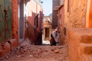 Kobieta idzie wzdłuż budynków uszkodzonych podczas trzęsienia ziemi w Marrakeszu, Maroko, 9.09.2023 r. (JALAL MORCHIDI/PAP/EPA)