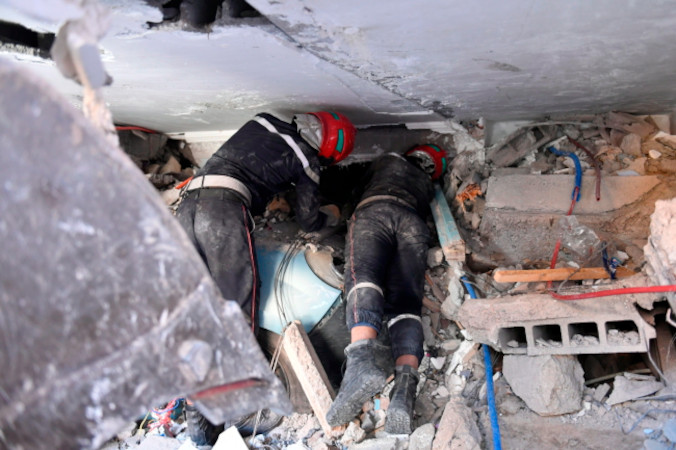 Ratownicy podczas akcji ratunkowej w uszkodzonym budynku po trzęsieniu ziemi w Marrakeszu, Maroko, 9.09.2023 r. (JALAL MORCHIDI/PAP/EPA)