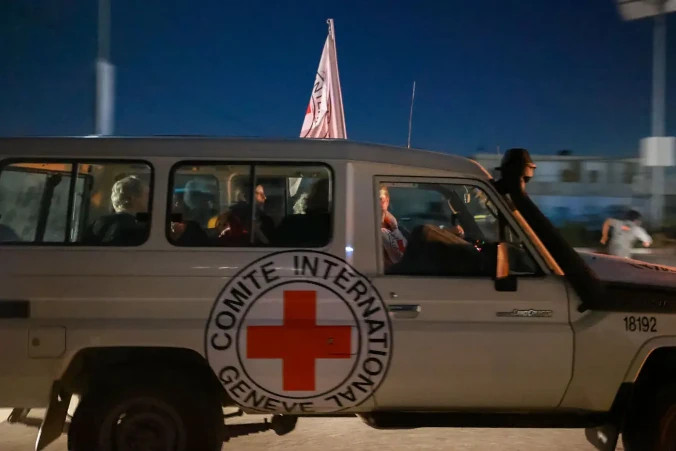 Samochód Międzynarodowego Czerwonego Krzyża przewożący zakładników uwolnionych przez Hamas przejeżdża przez punkt graniczny Rafah w Strefie Gazy w kierunku Egiptu, skąd uwolnieni zostaną przetransportowani do Izraela, aby połączyć się z rodzinami, 24.11.2023 r. (Mohammed Abed/AFP via Getty Images)