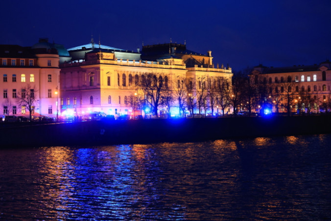 Światła pojazdów służb ratunkowych oświetlają miejsce strzelaniny na Uniwersytecie Karola w centrum Pragi, 21.12.2023 r. (MARTIN DIVISEK / PAP/EPA)
