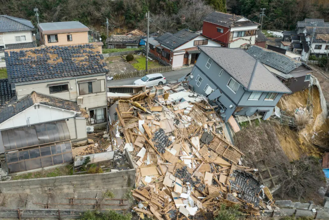 Uszkodzone i zniszczone domy wzdłuż ulicy w Wajima w prefekturze Ishikawa po silnym trzęsieniu ziemi, magnituda 7,5, które nawiedziło region Noto w prefekturze Ishikawa, zdjęcie lotnicze, 2.01.2024 r. (Fred Mery/AFP via Getty Images)