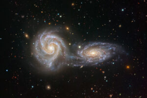 Zdjęcie ilustracyjne. Dwie galaktyki spiralne złączone w urzekającym tańcu na zdjęciu z instrumentu VIMOS na Very Large Telescope ESO. Dwie oddziałujące ze sobą galaktyki – NGC 5426 i NGC 5427 – tworzą razem intrygujący obiekt astronomiczny o nazwie Arp 271 (<a href="https://www.eso.org/public/images/potw1821a/">ESO/Juan Carlos Muñoz</a>, <a href="https://creativecommons.org/licenses/by/4.0/">CC BY 4.0</a>, zdjęcie modyfikowane / <a href="https://commons.wikimedia.org/w/index.php?curid=69339256">Wikimedia</a>)