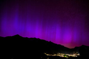 Zorza polarna rozświetla nocne niebo nad górami w Chateau-d’Oex w Szwajcarii, 11.05.2024 r. (JEAN-CHRISTOPHE BOTT/PAP/EPA)