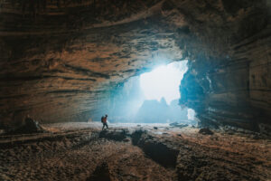 Jaskinie są ciekawymi obiektami nie tylko dla geologów. Zdjęcie ilustracyjne (<a href="https://unsplash.com/@ktsfish?utm_content=creditCopyText&amp;utm_medium=referral&amp;utm_source=unsplash">Lê Tân</a> / <a href="https://unsplash.com/photos/person-walking-towards-cave-ymPtFTBz1zA?utm_content=creditCopyText&amp;utm_medium=referral&amp;utm_source=unsplash">Unsplash</a>)