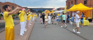 Praktykujący podczas drugiego ćwiczenia przy stoisku Falun Dafa na terenie Manufaktury, Łódź, 27.07.2024 r. (The Epoch Times)