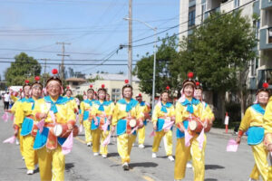 Praktykujący Falun Gong zostali zaproszeni do udziału w Wielkiej Paradzie Festiwalu Kwitnącej Wiśni w rejonie Zatoki San Francisco, 1 czerwca. Na zdjęciu 77-letnia Yang (w pierwszym rzędzie, najbardziej na prawo) gra na tradycyjnym chińskim instrumencie ludowym – bębenku bocznym yaogu – wraz z orkiestrą bębniarek Falun Gong (The Epoch Times)