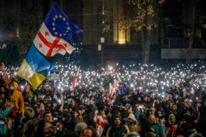 Zwolennicy gruzińskiej opozycji trzymają flagi UE, Gruzji i Ukrainy podczas protestu przed budynkiem parlamentu w Tbilisi, Gruzja, 30.11.2024 r. (DAVID MDZINARISHVILI/PAP/EPA)