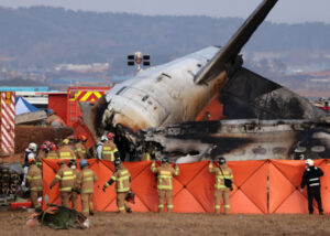 Strażacy przeszukują wrak samolotu Jeju Air na międzynarodowym lotnisku Muan, 288 km na południowy zachód od Seulu, Korea Południowa, 29.12.2024 r. (HAN MYUNG-GU/PAP/EPA)